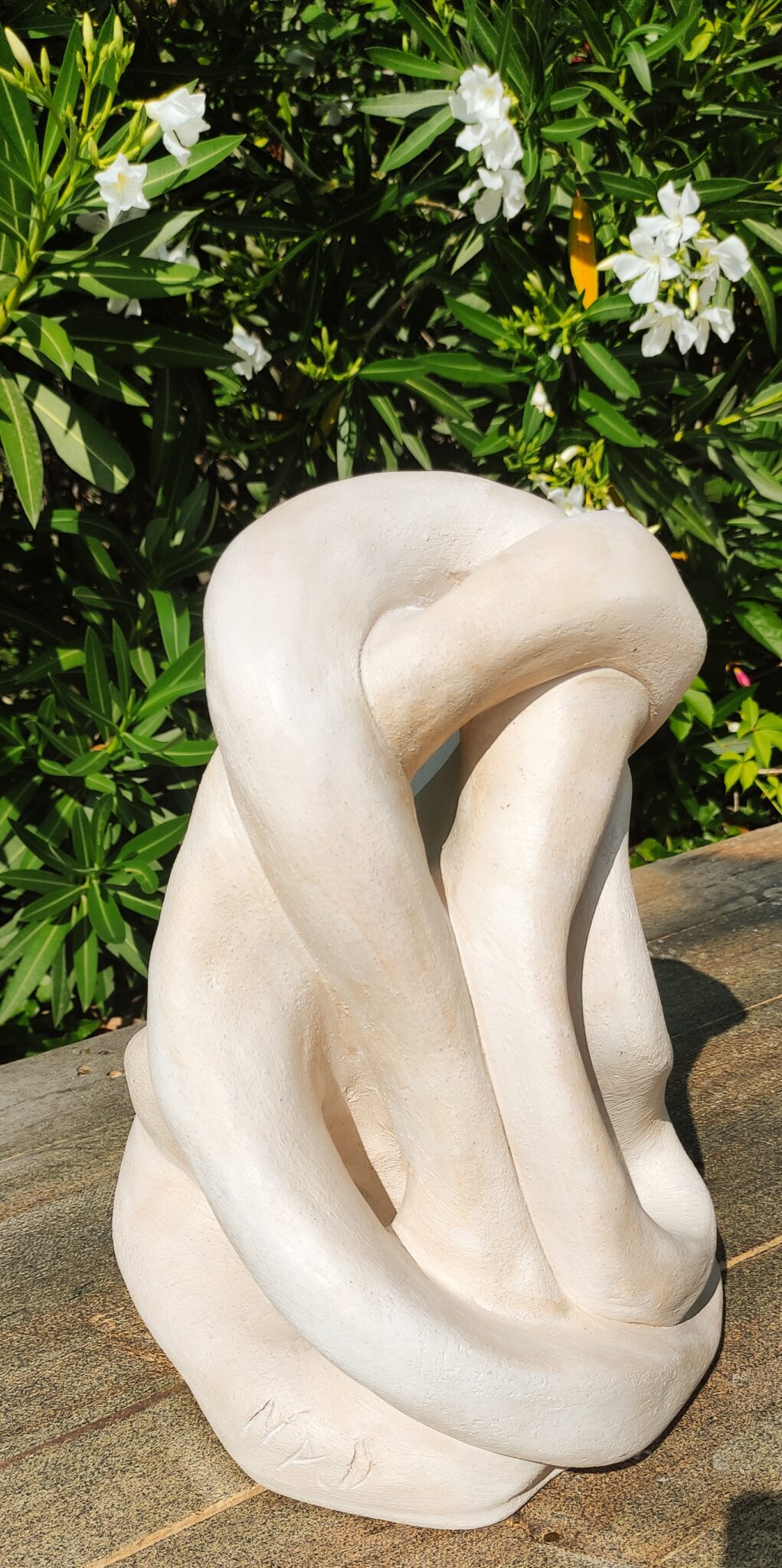 Terre cuite patinée représentant une forme abstraite d'un lien qui court sans fin en boucle. Coloris beige