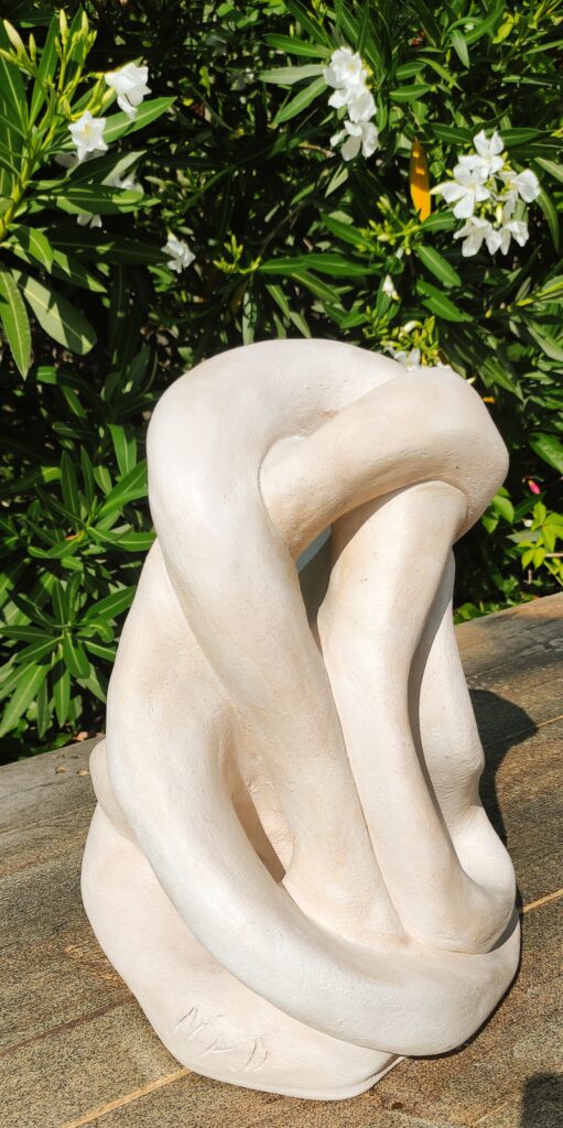 Sculpture en terre cuite patinée représentant une forme abstraite d'un lien qui court sans fin en boucle. Coloris beige. Aix-en-Provence