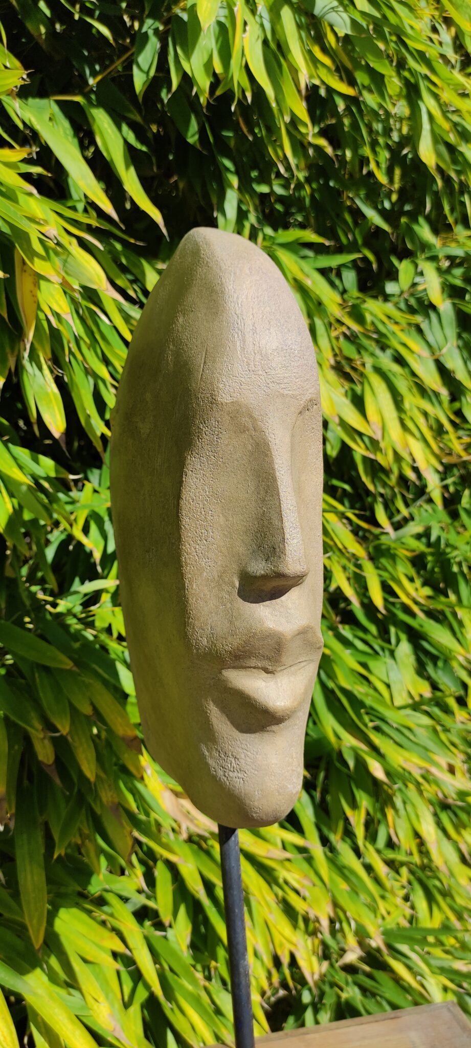 Sculpture d'une tête stylisée en terre cuite patinée ton pierre