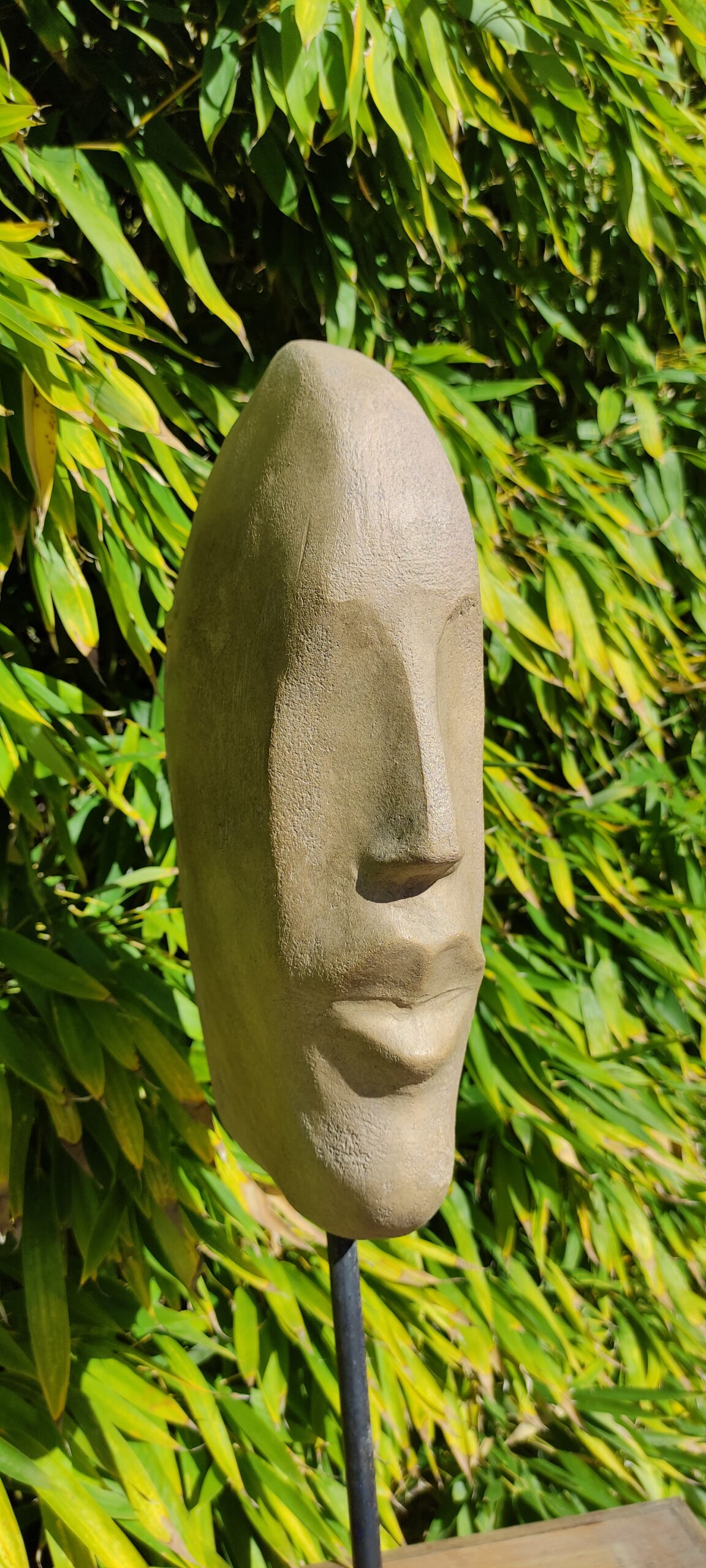 Sculpture d'une tête stylisée en terre cuite patinée ton pierre